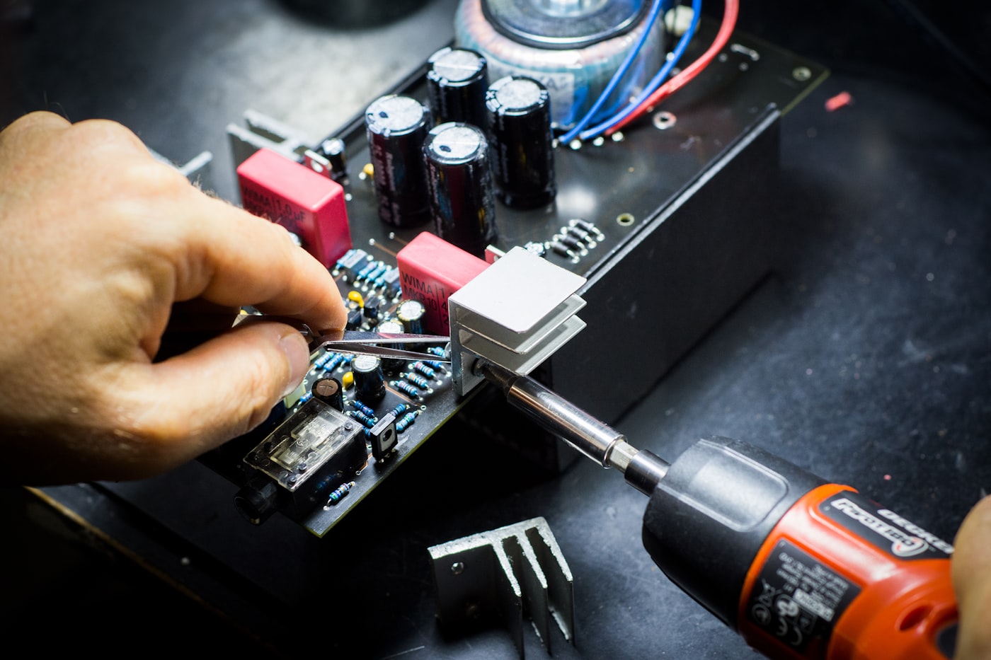Hands assembling components on a circuit board